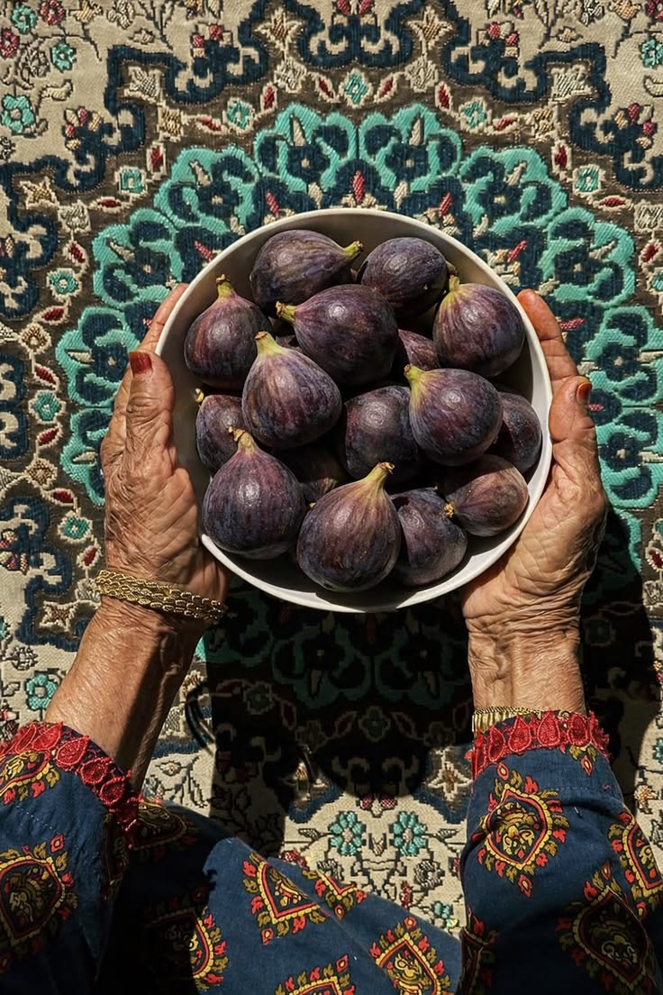 Mains de grand-mère tenant un bol de figues