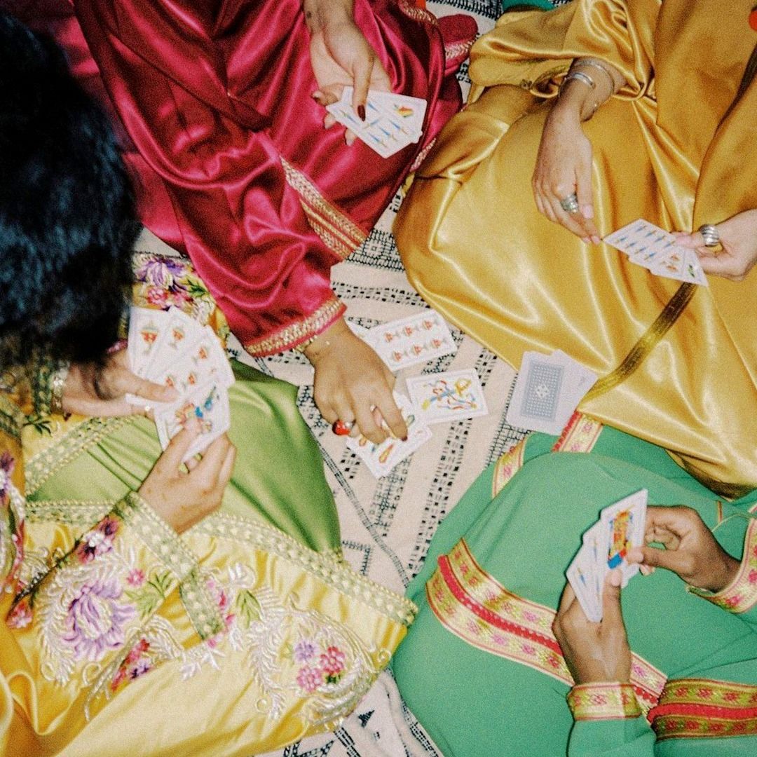 Jeu de cartes entre femmes en caftans